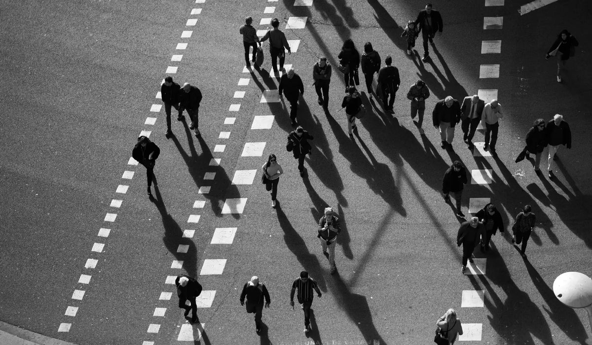 Black and white photo of people walking on a crosswalk
