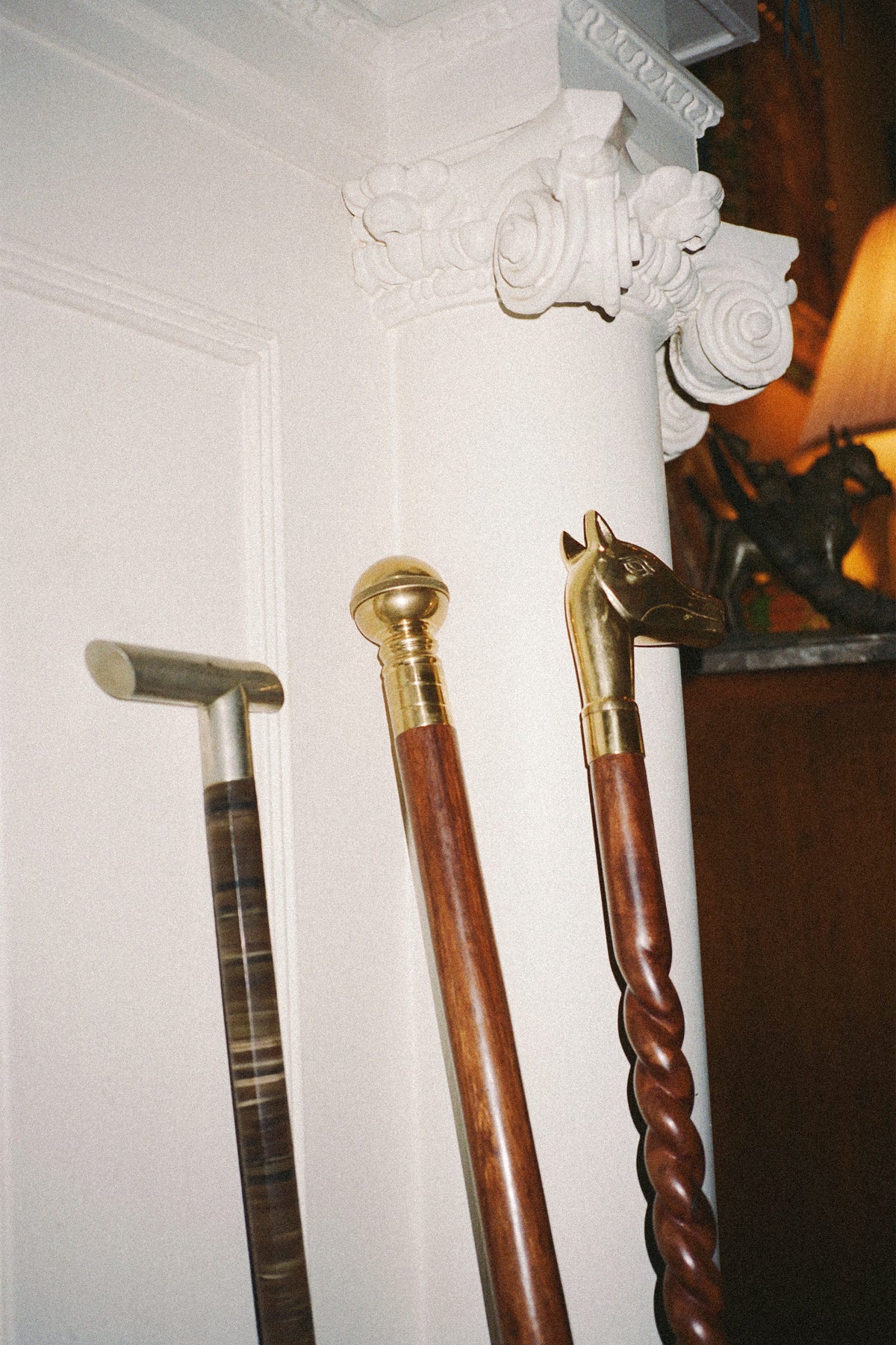 Three walking canes leaning against a white column