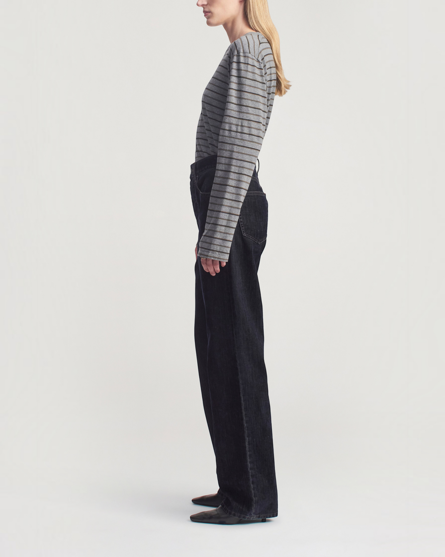 Weldun Wynn long sleeve charcoal striped cotton tee with a relaxed boxy fit tucked into dark denim trousers